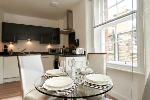 爱丁堡Braid Apartments by Mansley的厨房配有带盘子和玻璃杯的桌子