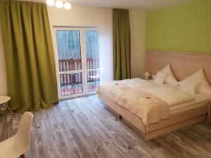 哈弗尔河畔勃兰登堡Neue Mühle Kleines Landhotel的一间卧室设有一张床和一个大窗户