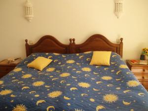 卡武埃鲁Casa Esperanca的一张带黄色鲜花的蓝色棉被的床