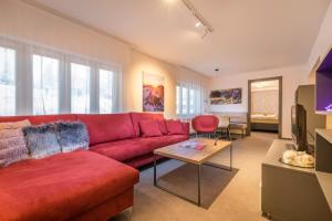 诺维斯莫克维克Apartman Smokovec的客厅配有红色的沙发和桌子