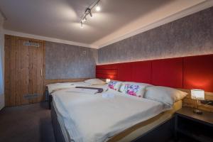诺维斯莫克维克Apartman Smokovec的一间卧室配有一张大床和红色床头板