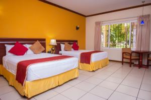 San LuisPato Canales Hotel & Resort的酒店客房设有两张床和窗户。