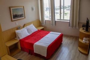巴西利亚艾拉姆巴西利亚酒店的卧室配有红色和白色的床,设有窗户