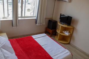 巴西利亚艾拉姆巴西利亚酒店的一间卧室配有一张带电视的床和一张四柱床。