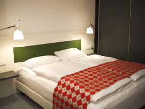 科隆达斯科隆酒店的床上有红白的毯子