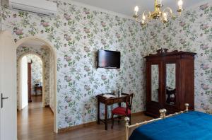 佛罗伦萨佩蒂尼酒店的卧室配有一张床,墙上配有电视。