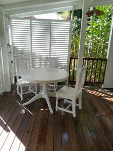 勒迪亚芒la case dentelle bungalow的门廊上的白色桌椅