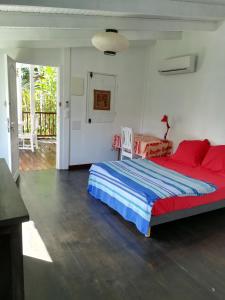 勒迪亚芒la case dentelle bungalow的一间卧室配有一张大床,铺有红色和蓝色的床单