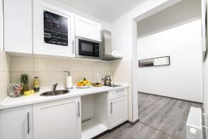 布达佩斯Annabelle Downtown Apartments的白色的厨房配有水槽和微波炉