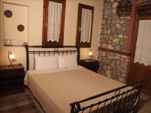 奥吉欧司吉玛洛斯Varnous Hotel的一间卧室设有一张床和石墙