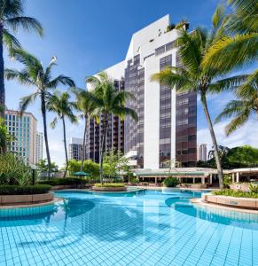 吉隆坡吉隆坡千禧大酒店的一座高楼前的棕榈树游泳池