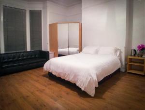 蒂斯河畔斯托克顿OutRam 26的卧室配有白色的床和黑色沙发
