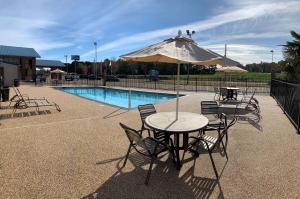 霍普豪普贝斯特韦斯特酒店的游泳池旁配有遮阳伞的桌椅