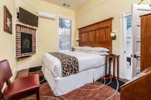 纳帕Hotel Napa Valley, Ascend Hotel Collection的一间卧室配有一张床和一个壁炉