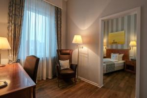 汉诺威汉诺威萨沃伊酒店的酒店客房,配有一张床、一张桌子和椅子
