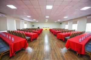 坎帕拉Nyumbani Hotel的宴会厅配有红色桌子和椅子及红色桌布