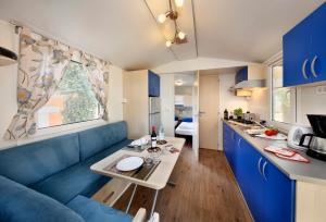 卡里高多Albatross Mobile Homes on Camping Park Umag的客厅配有蓝色的沙发和桌子