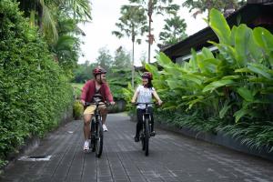 海神庙海神庙纳特雅酒店的骑着自行车的男人和女人