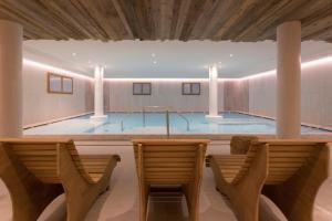 摩德纳迪-坎皮格里奥玫瑰园酒店的一个带两把椅子的房间的游泳池