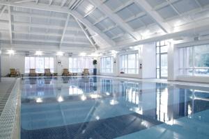 布兰登Brandon Hall Hotel & Spa Warwickshire的大楼内一个蓝色的大型游泳池