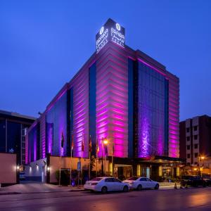 利雅德Braira Al Olaya的建筑的侧面有紫色的灯