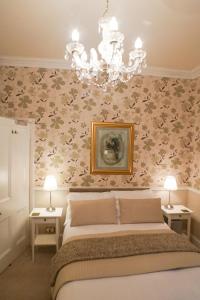 利明顿温泉Hedley Villa Guest House的一间卧室配有一张床和一个吊灯