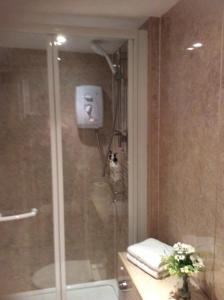 利明顿温泉Hedley Villa Guest House的带淋浴的浴室,配有毛巾