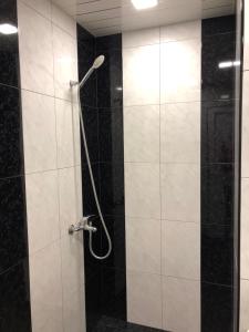 杰尔穆克Rest home Jermuk的浴室铺有黑白瓷砖,设有淋浴。