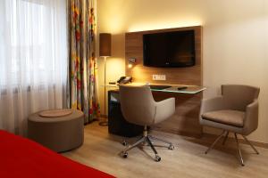 汉诺威法克图姆宫廷酒店的酒店客房配有书桌和电视。