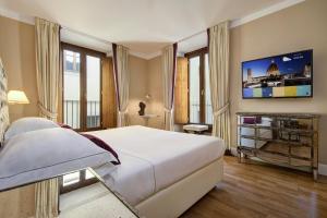 佛罗伦萨凯沃尔大酒店的卧室配有一张白色大床和电视。