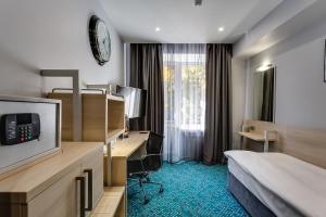 顿河畔罗斯托夫马林斯公园酒店的配有一张床和一张书桌的酒店客房