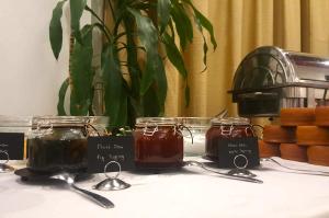 锡季罗卡斯特龙阿格楠希欧温泉酒店的一张桌子,上面有三罐蜂蜜和勺子