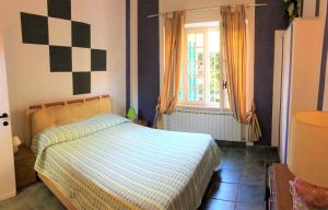 卡尼洛瑞维拉Appartamento Tennis的一间卧室配有一张带 ⁇ 子毯子的床和窗户