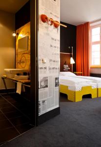 汉堡Superbude Hamburg St Pauli的一间卧室配有一张床,墙上配有报纸