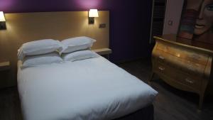 阿雅克修科瓦尔布朗克酒店的卧室配有白色的床和梳妆台。