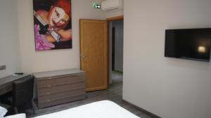阿雅克修科瓦尔布朗克酒店的一间配有电视的房间,墙上挂着一幅画
