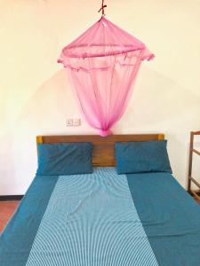 亭可马里Sai Seashell Rest Inn Nilaveli的一张挂在上面的粉红色伞床