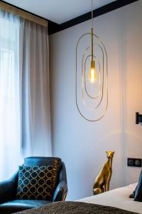 南特Maisons du Monde Hotel & Suites - Nantes的卧室,卧室的椅子上摆放着狗,床边摆放着椅子