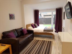 切尔滕纳姆Leckhampton Road Apartments - Cheltenham的客厅配有沙发和1张床
