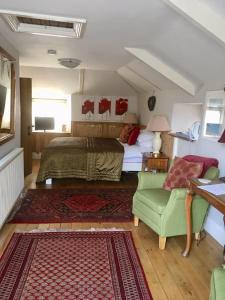 卡姆尔福德Culloden Farmhouse的一间卧室配有一张床和一把绿色椅子