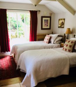 卡姆尔福德Culloden Farmhouse的一间卧室设有两张床和窗户。