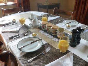 Rufford庄园农场住宿加早餐旅馆的桌子上放有盘子和橙汁杯