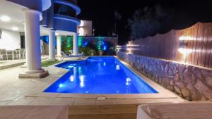 埃拉特Luxury Suite by the pool的夜间游泳池,灯光照亮
