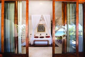 图卢姆图卢姆海滩酒店的一间卧室配有白色窗帘的床