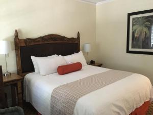 圣巴巴拉老鹰旅馆的一间卧室配有一张大床,上面有红色枕头
