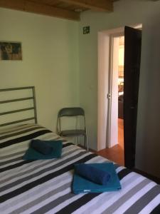 塞卡尔Quinta Boavista的一间卧室配有一张带2条蓝色毛巾的床