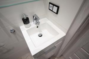 罗兹Apartament Manufaktura的客房内的白色盥洗盆浴室