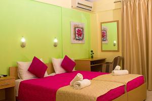 斯基亚索斯镇雅典娜一室公寓酒店的一间卧室配有两张带粉红色床单的床