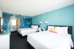 丘拉维斯塔Rambler Motel的两张位于酒店客房的床,拥有蓝色的墙壁