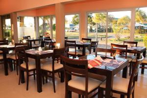 费德拉西翁萨斯拉戈Y公寓酒店的餐厅设有木桌、椅子和窗户。